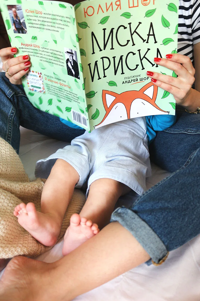 Детская книга «Лиска Ириска» в руках рядом с малышом
